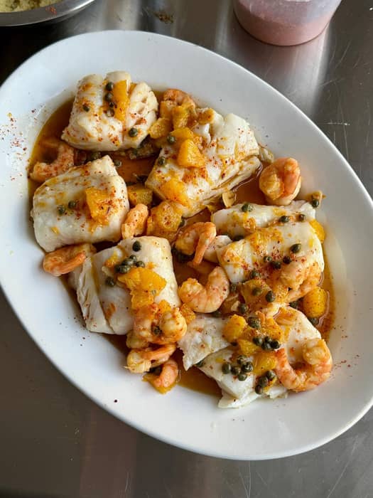 Summer in winter. I’ve still got loads of oranges because it’s citrus season, so I made this for Sunday lunch. Baked cod, then prawns fried in the best extra virgin olive oil you can get, with garlic and chilli. Turn off the heat, then add segments from one orange + juice and zest, a splash of vinegar and some capers.

Poured over the cod and served with cous cous (you might think, no thanks, but it soaks up all the juices perfectly, so trust me), plus whatever veg or herbs you want. The easiest thing to serve 4–6 people, 10-15 mins to make and the flavours I crave in January. 
Would be also be great with crispy potatoes and poured over a whole roast fish.