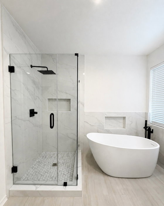 Yellow walls, boxed-in shower, a jet tub that’s seen better days. Gone.

Now it’s marble-look tile, 