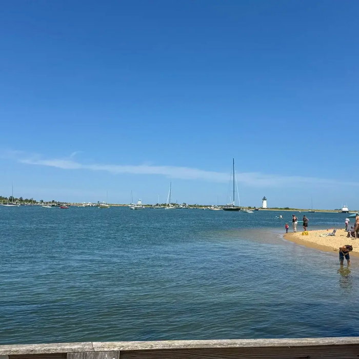 Looking across Edgartown harbor from the Chappy side. Lighthouse in the distance, people in the wate...