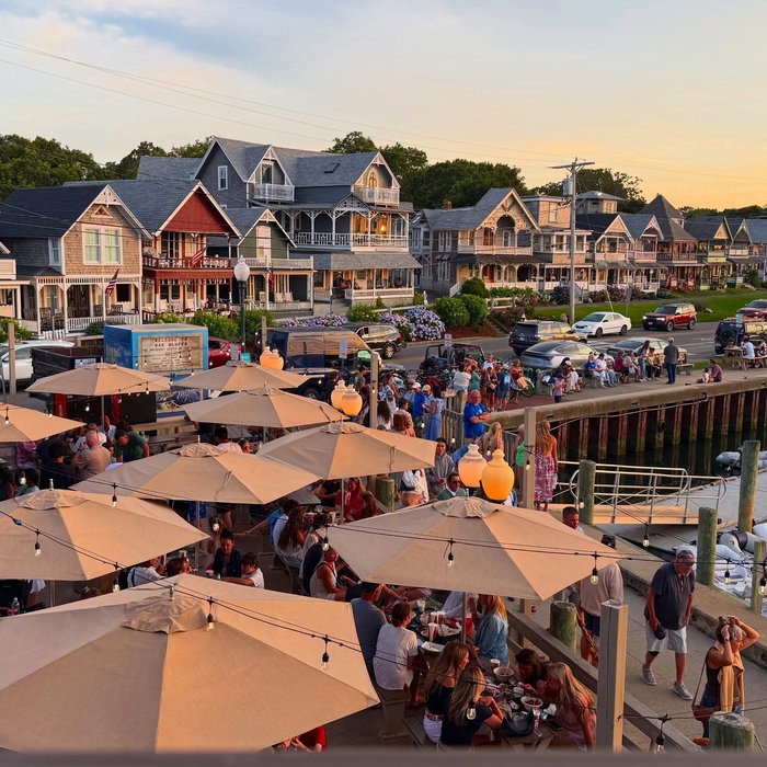 Golden hour over Oak Bluffs harbor, looking out from Nancy’s. Umbrellas, cottages catching the last...