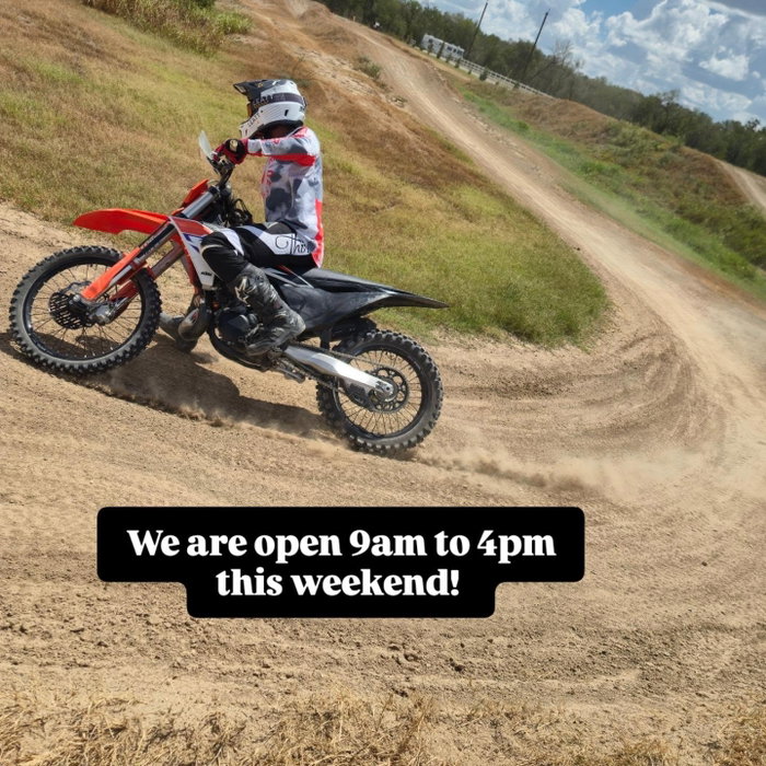 A rider catching air over a Creekside jump on a red motocross bike