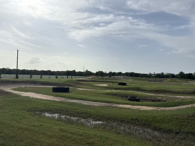 A view across the green infield and dirt tracks at Creekside MX
