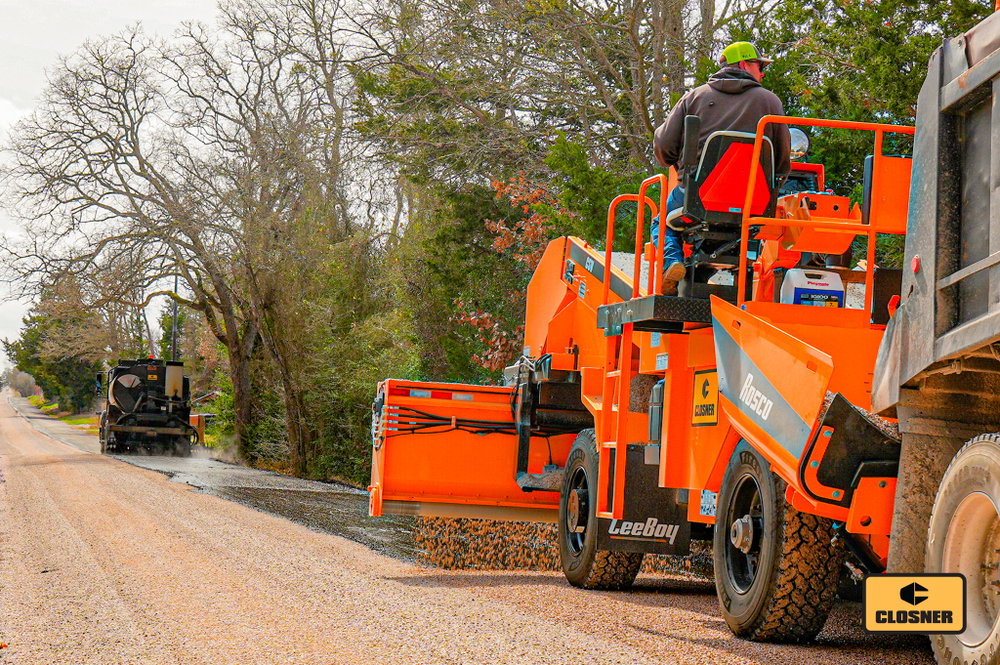 A textbook chip seal operation in Bastrop County.
This ROSCO Maximizer 3B Distributor is laying down a consistent application while the ROSCO CSV Chip Spreader follows close behind, keeping the process moving efficiently and the crew productive.