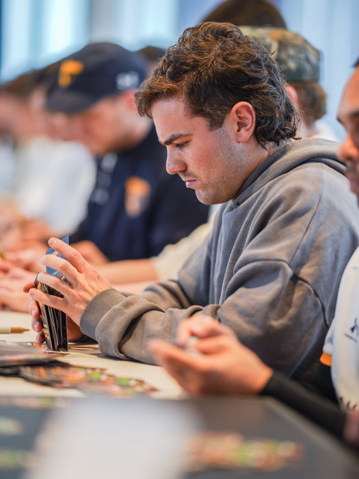 The Hawks are getting their footy cards signed by the players, ready to hand out to members as a special thank you for t