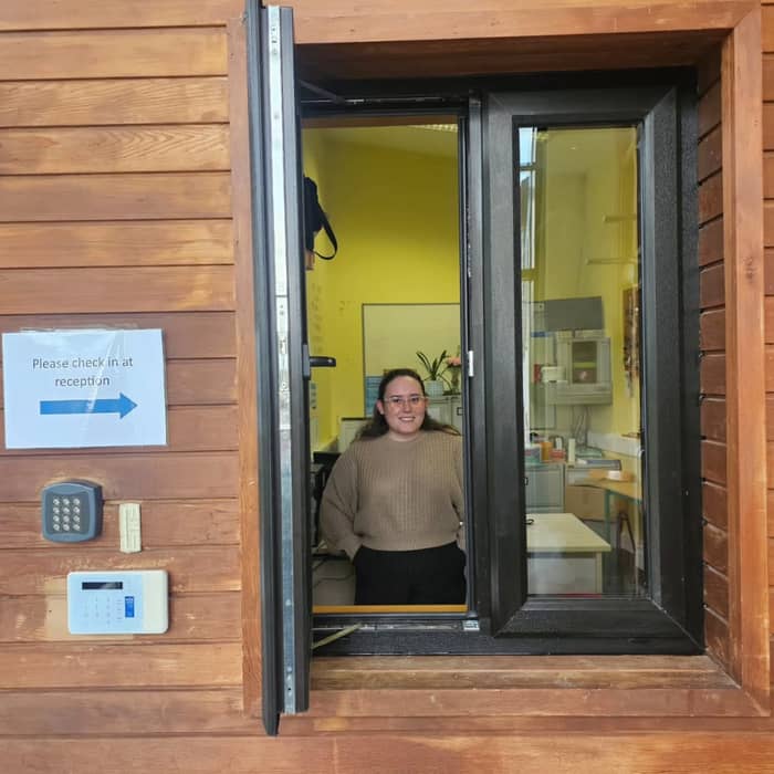 Our secretary, Róisín, ready to greet everyone through her new hatch window at reception 😀. Please check in here first on arrival to school.